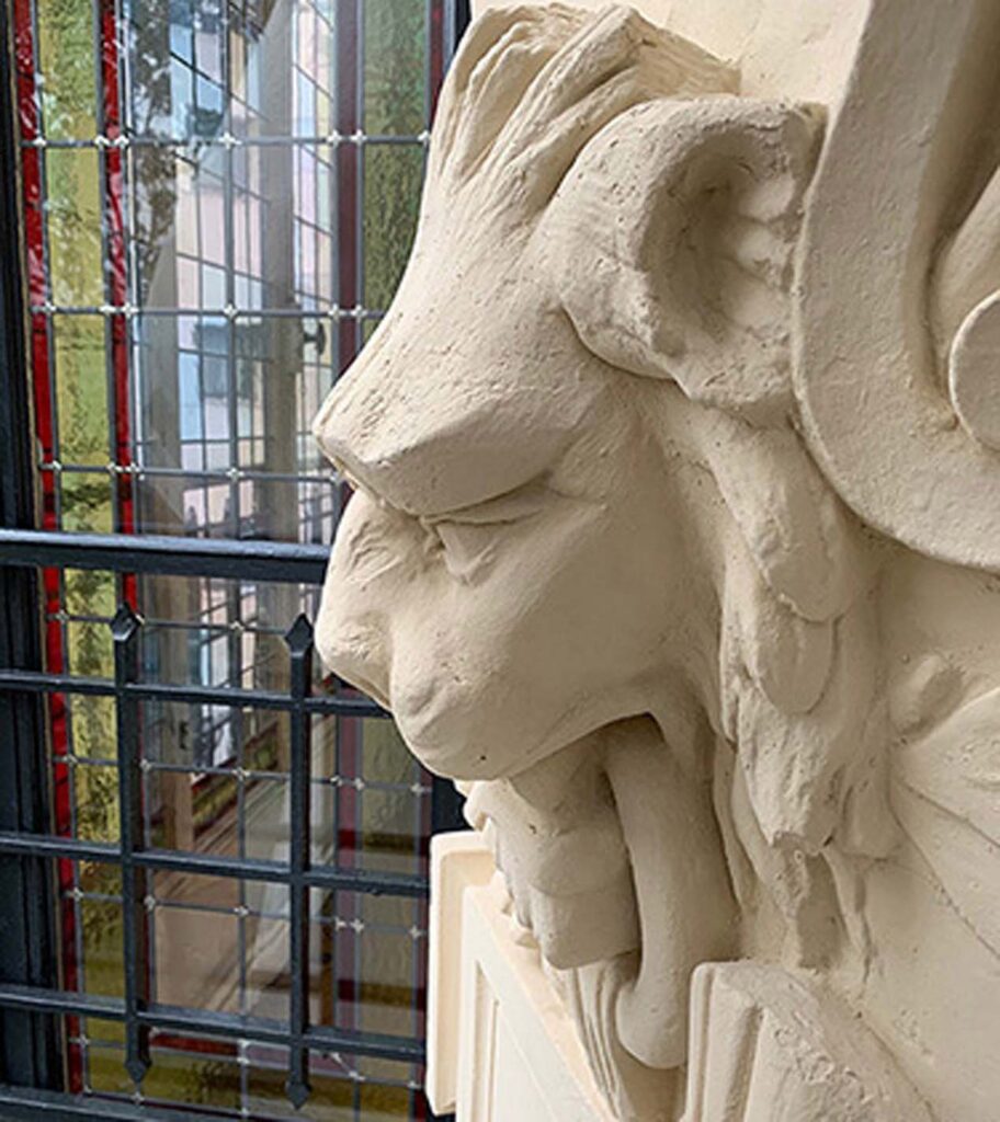 Tête de lion sculpté dans le mur d'un hall d'entrée d'immeuble à Daumesnil